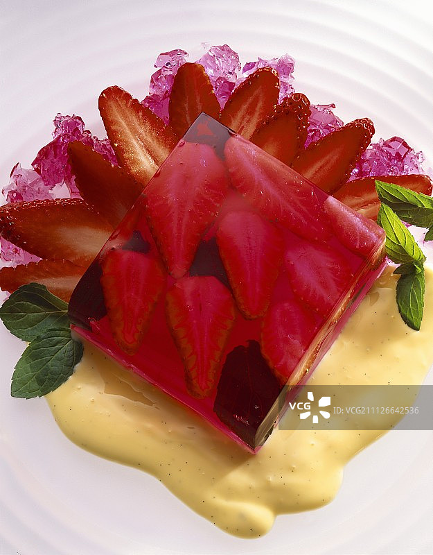 香草酱上的草莓果冻立方体和薄荷叶图片素材