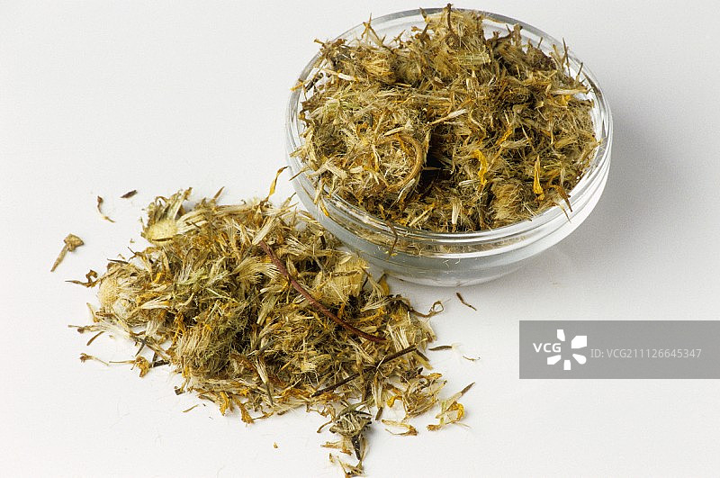 玻璃碗内外散落的干山金车花图片素材