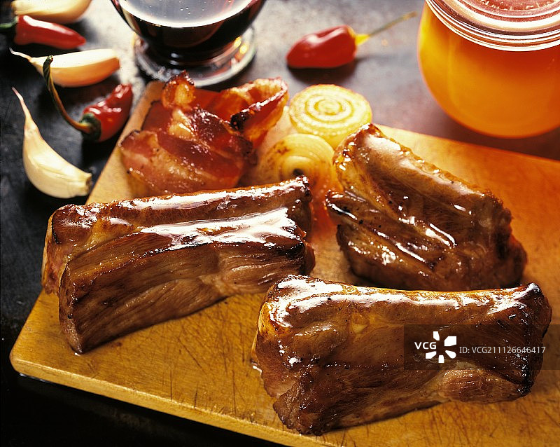 木板上的三根排骨；培根和洋葱图片素材