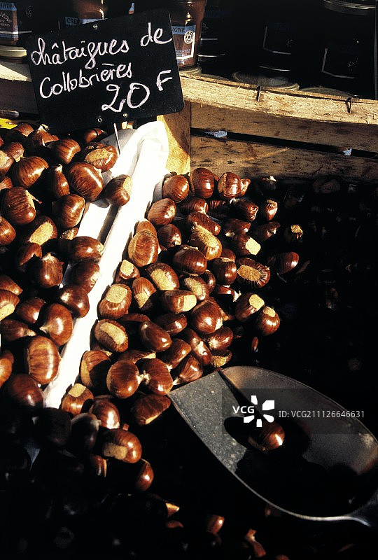 男子在户外市场卖栗子图片素材