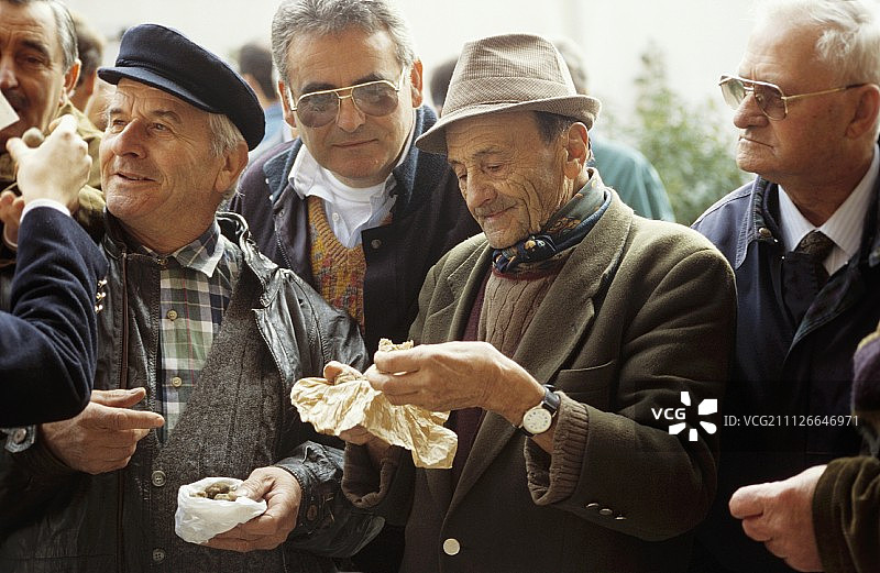 男人们在阿尔巴的松露市场检查松露图片素材