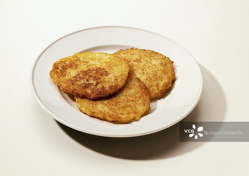 盘子里的三个土豆煎饼图片素材