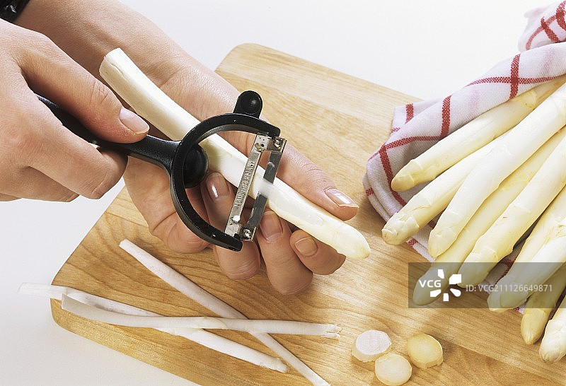 用蔬菜削皮器削白芦笋图片素材
