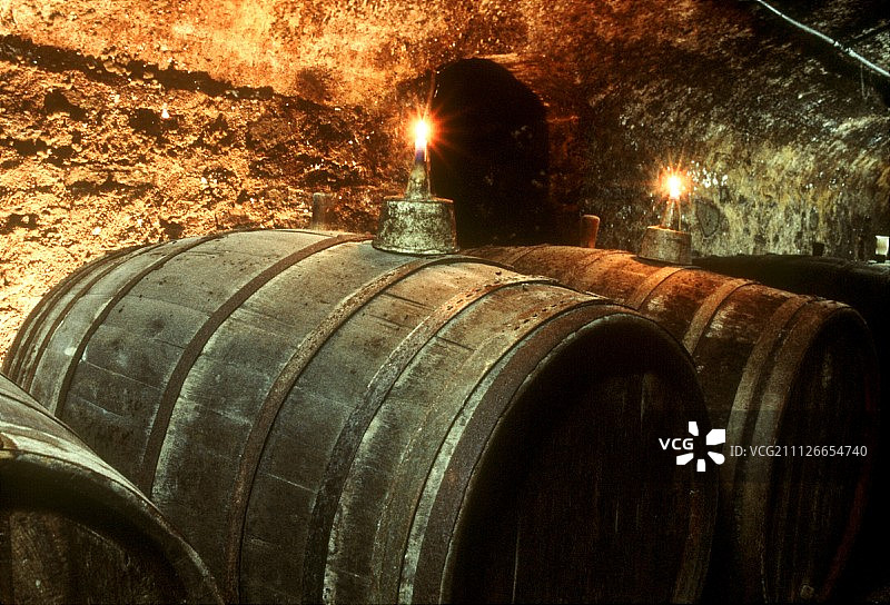 Gietzen酒庄拱形地窖中葡萄酒桶上的蜡烛图片素材