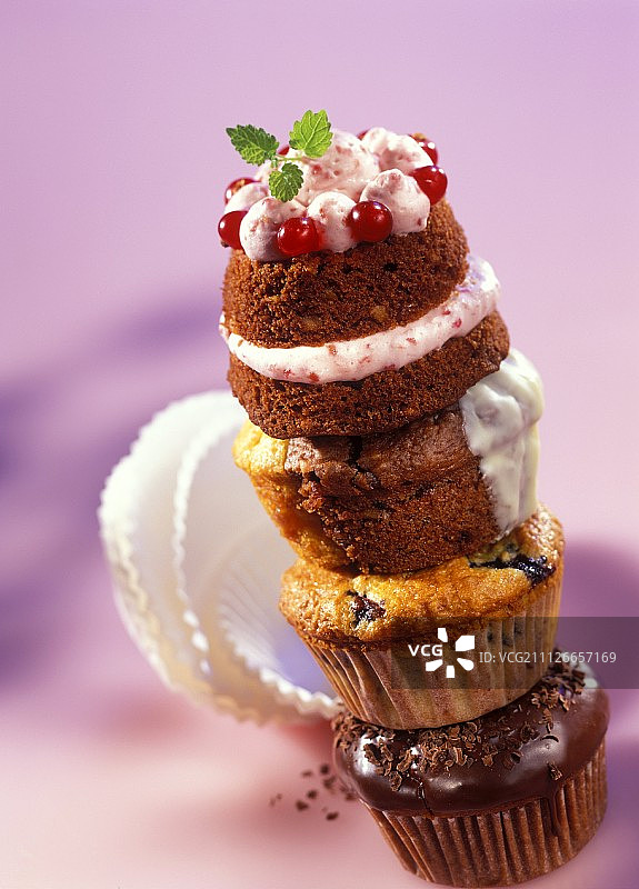 叠放的四个玛芬蛋糕，顶部配红醋栗奶油图片素材