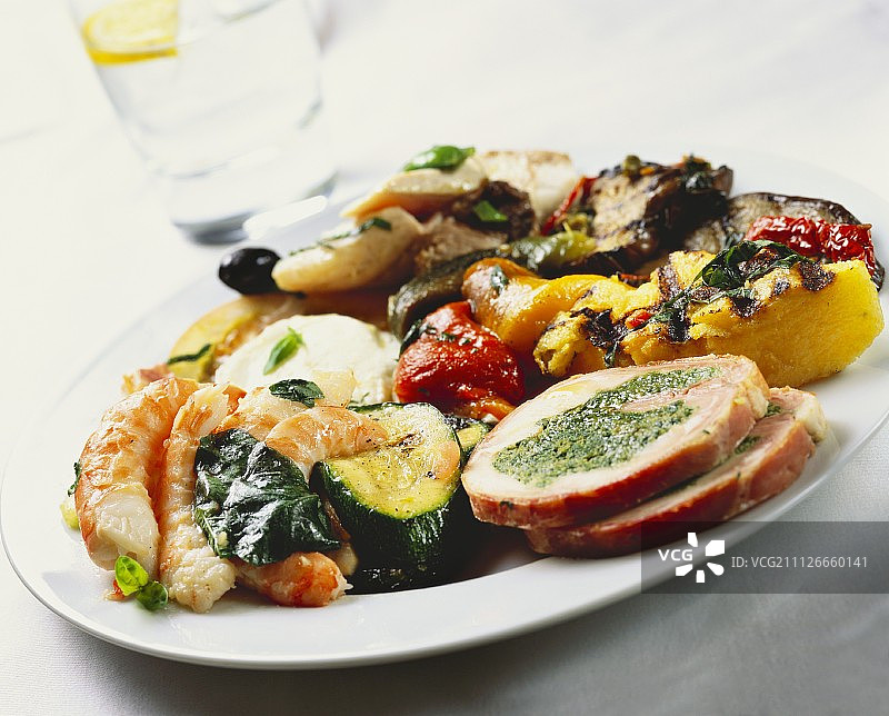 烤什锦拼盘配虾、火鸡肉卷、玉米粥和蔬菜图片素材