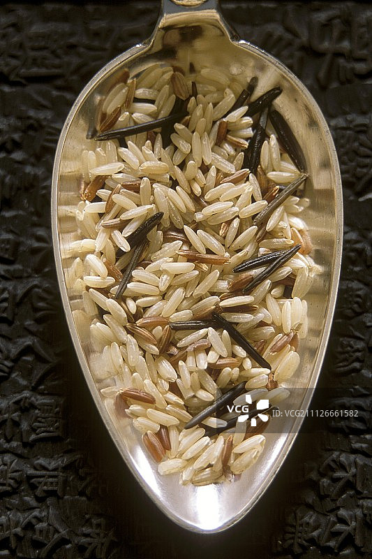 银勺上的未煮的混合野生稻图片素材