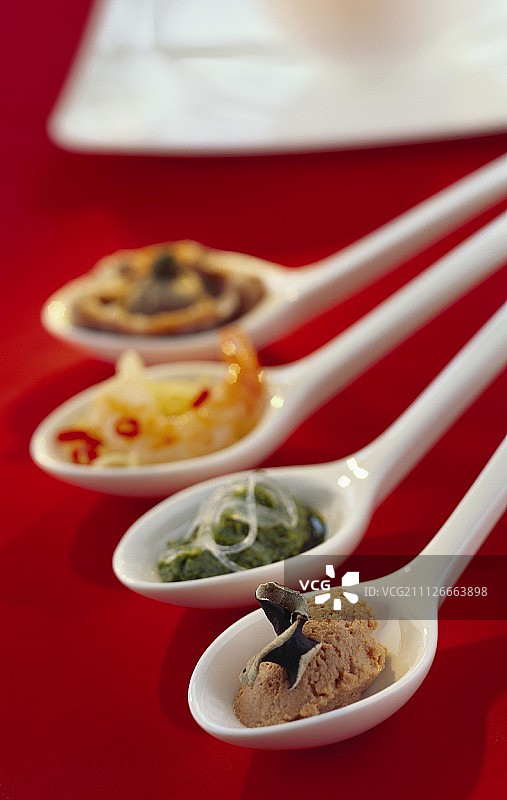 瓷勺盛装的各种咸味小吃图片素材