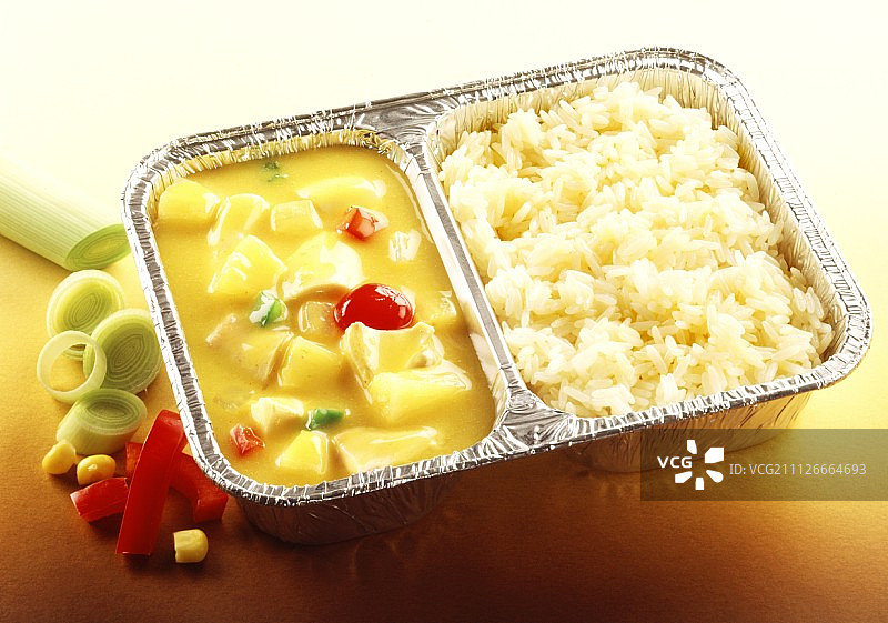 速食食品：铝盘中的咖喱鸡肉、菠萝和米饭图片素材