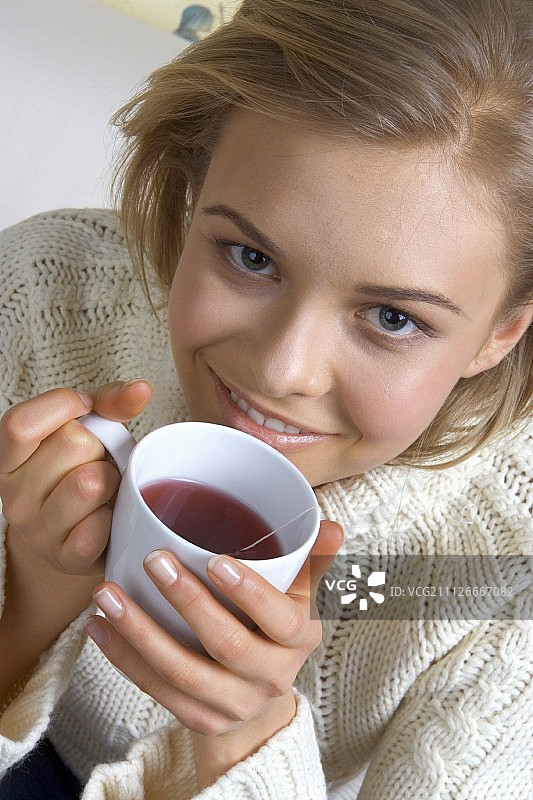年轻女子手捧热饮杯图片素材