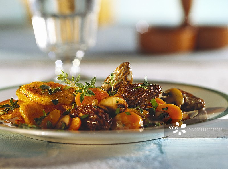 盘中胡萝卜、羊肚菌、土豆和百里香图片素材