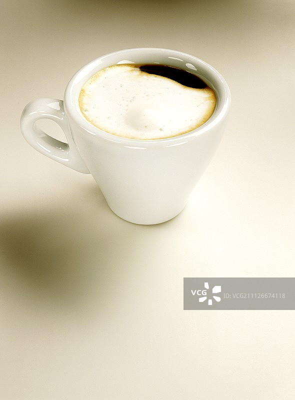 白色意式浓缩咖啡杯中的玛奇朵咖啡（含奶沫）图片素材
