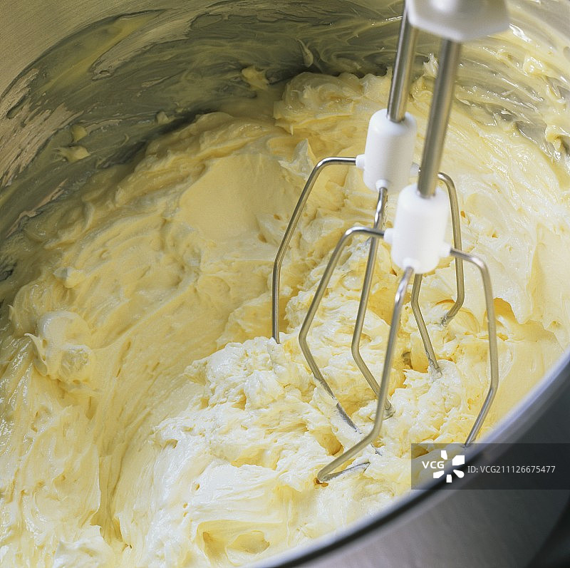 制作奶油蛋糕混合物：用手动搅拌器将黄油打发图片素材