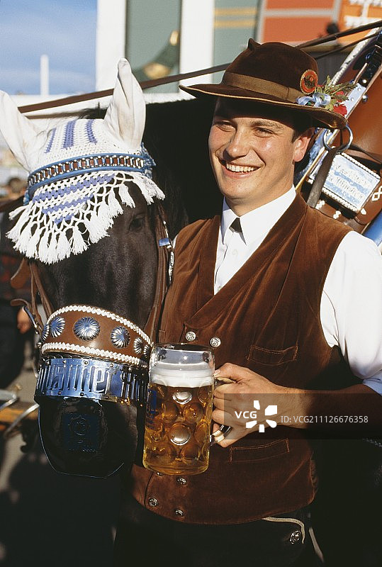 慕尼黑啤酒节上的马车夫与啤酒杯和装饰马图片素材