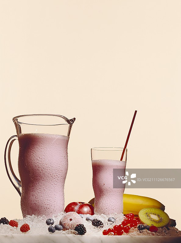 玻璃杯和水罐中的冰镇浆果奶昔图片素材