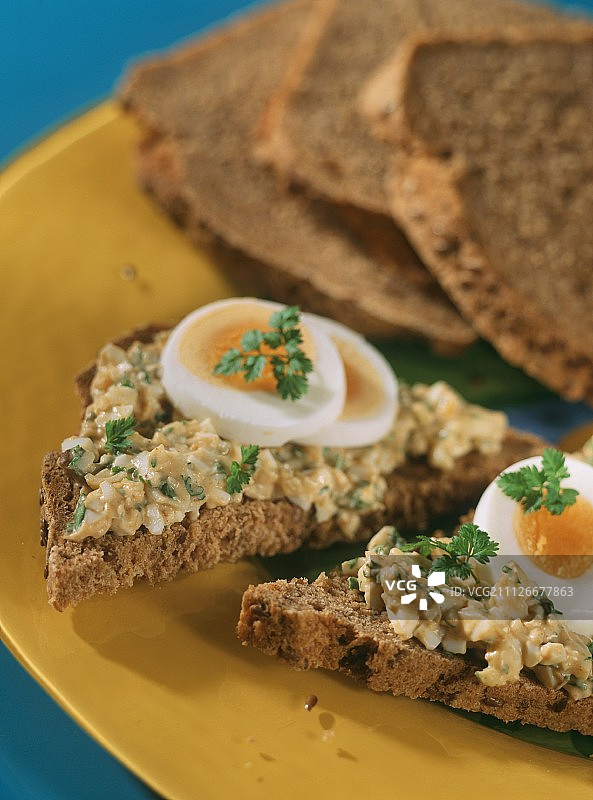 亚麻籽面包配鸡蛋酱，黄色餐盘图片素材