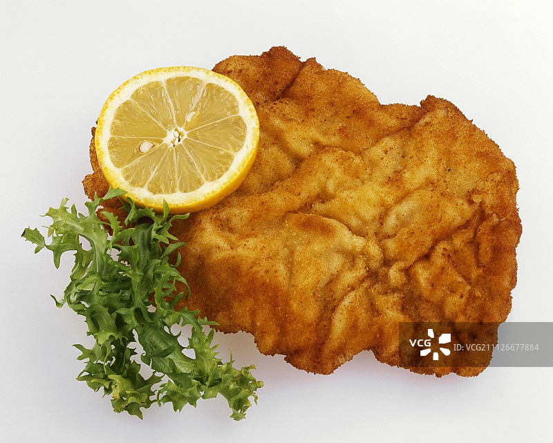 炸维也纳小牛排配柠檬片和莴苣叶图片素材