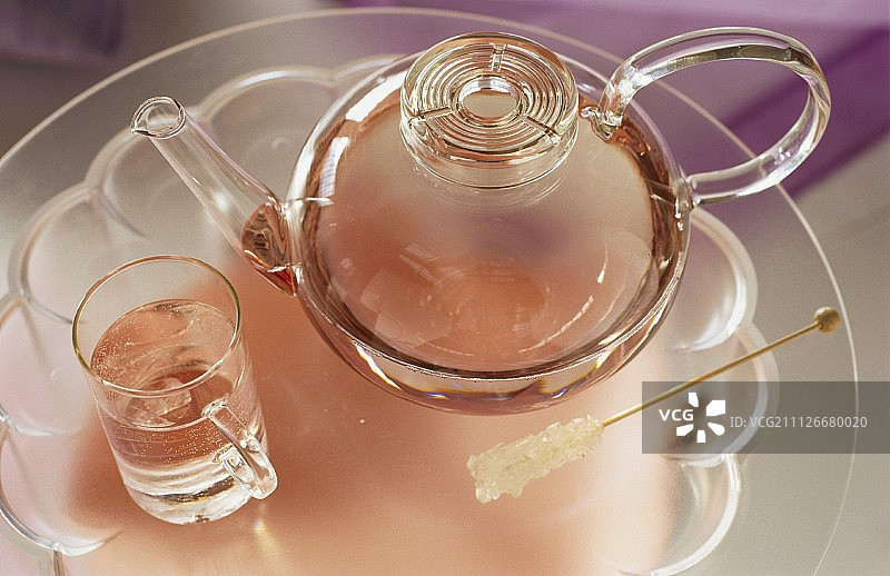 玻璃茶壶和玻璃杯中的茶；冰糖图片素材