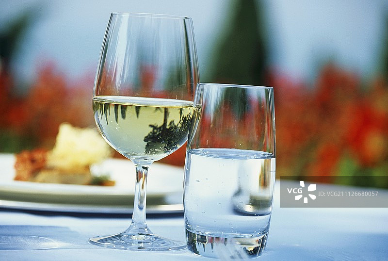 露天餐桌上的白葡萄酒杯和水杯图片素材