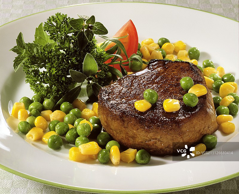 鲜嫩牛排配甜玉米、豌豆和香草图片素材