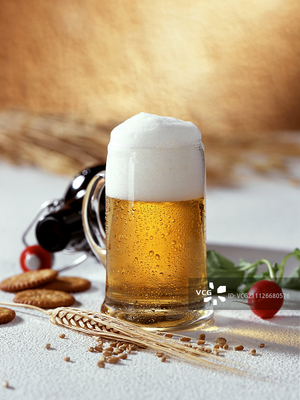 玻璃杯中的淡啤酒、萝卜、饼干和玉米穗图片素材