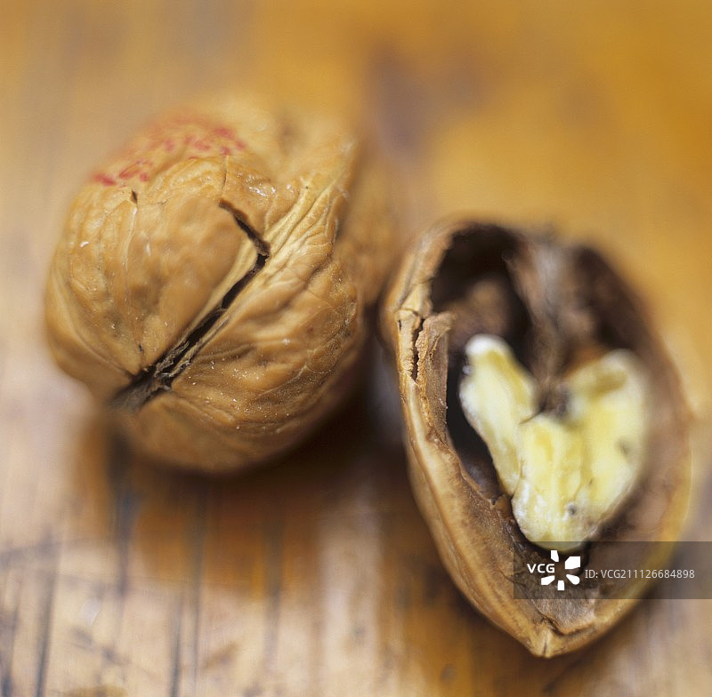 木制背景上的完整和一半的核桃图片素材