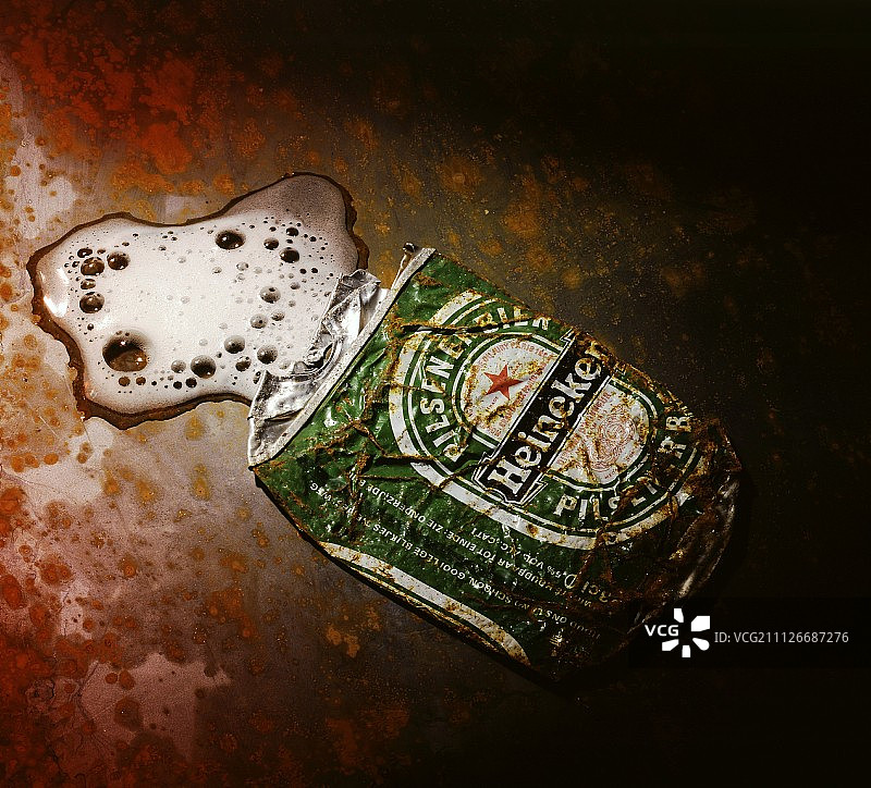 压扁的带泡沫的啤酒罐图片素材