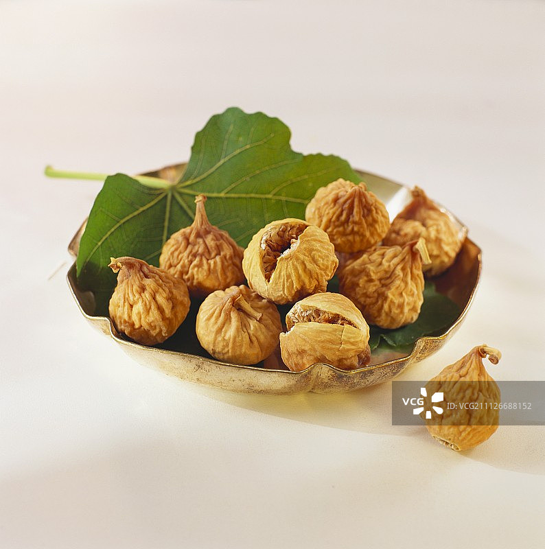 银碗中树叶上的无花果干图片素材