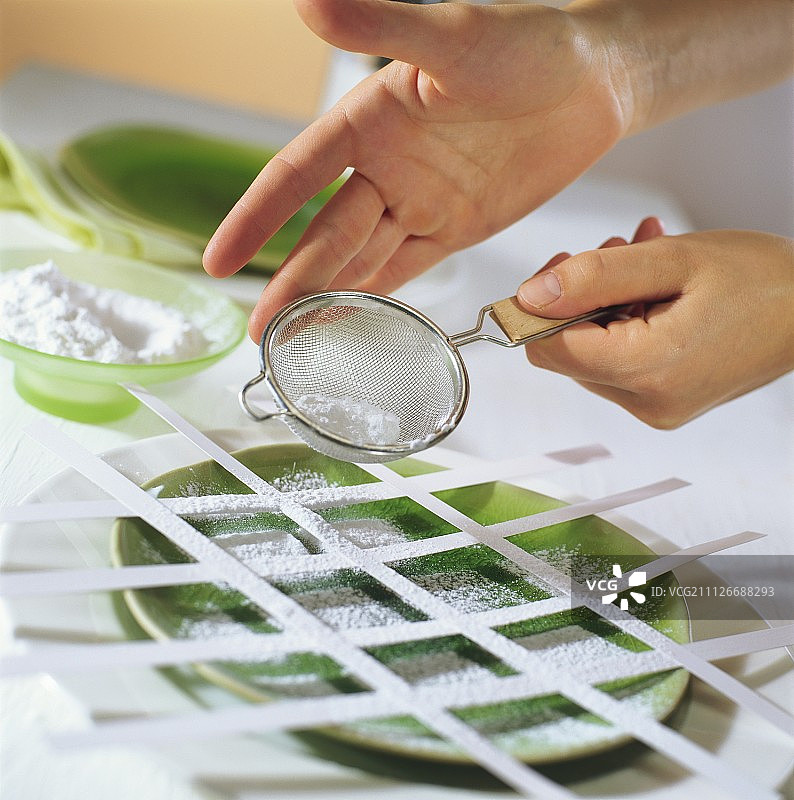 手在盘子上筛糖粉图片素材