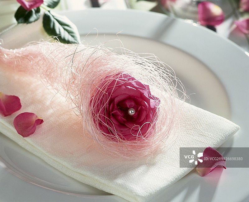 玫瑰和白色天使发丝装饰的餐巾图片素材
