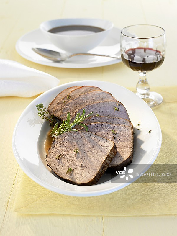 几片烤牛肉配肉汁和香草图片素材