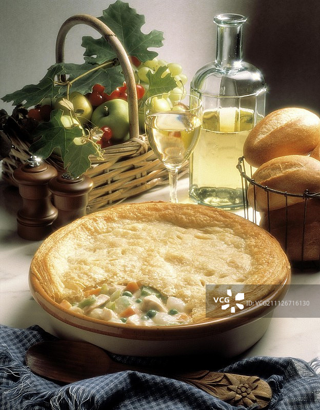 烤盘里的鸡肉蔬菜馅饼、葡萄酒、面包和水果图片素材