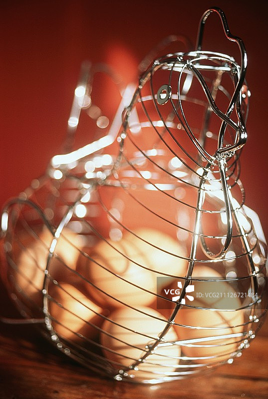 母鸡造型的金属篮子里的棕色鸡蛋图片素材