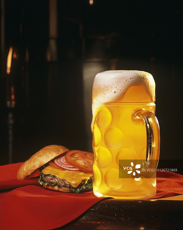 装满啤酒和芝士汉堡的马克杯图片素材