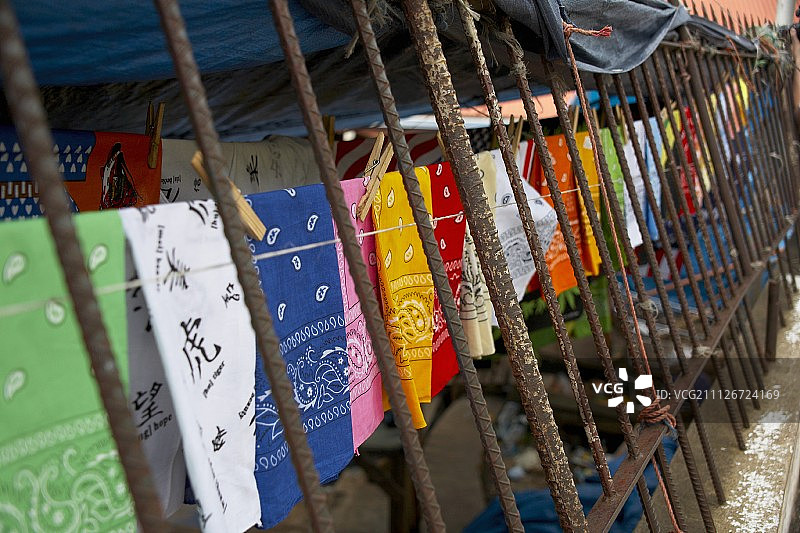 挂在铁栅栏上彩色头巾图片素材