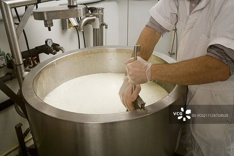 男人搅拌凝乳和乳清图片素材