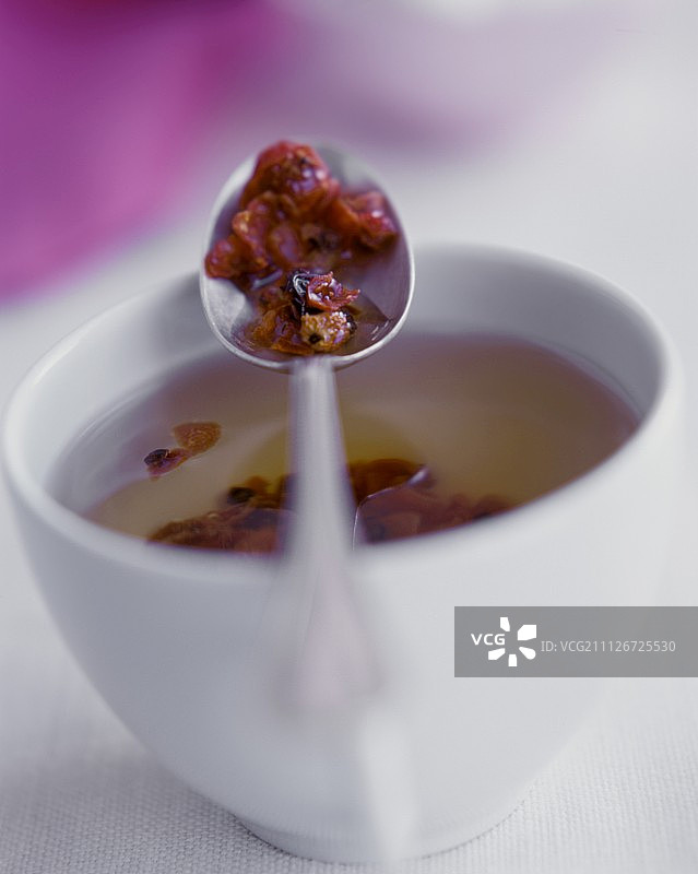 杯子和勺子里的玫瑰果茶图片素材