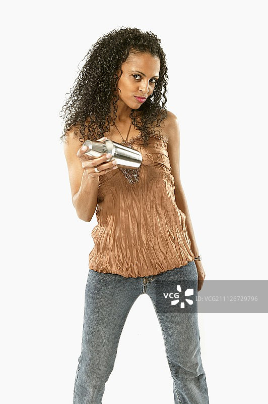 年轻女人摇动鸡尾酒调酒器图片素材