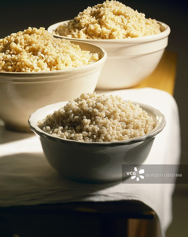 两碗煮熟的谷物：大麦和米饭，一碗煮熟的蒸粗麦粉图片素材