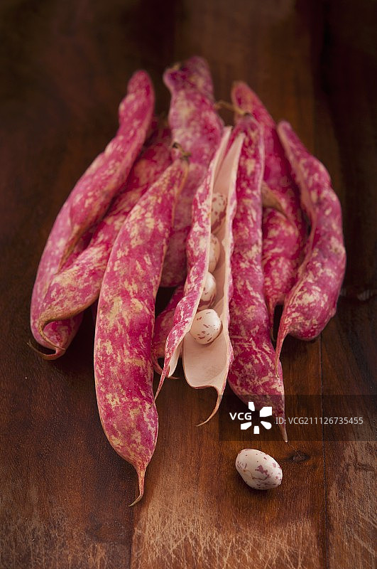 木制砧板上的博洛蒂豆荚和豆子图片素材