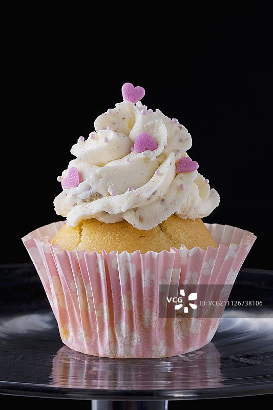 用奶油和粉色心形装饰的纸杯蛋糕图片素材