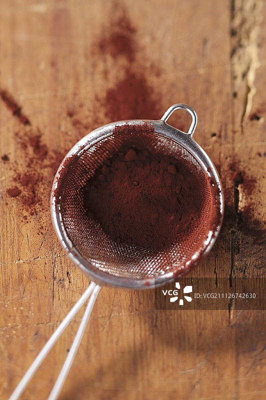 木质表面筛子里的可可粉图片素材