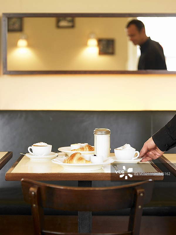 小餐馆的早餐餐桌：卡布奇诺和羊角面包图片素材