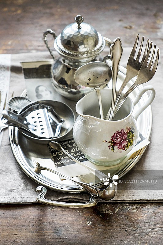 瓷壶中的银色餐具和托盘上的柠檬榨汁器图片素材