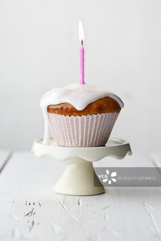 糖霜滴落的带蜡烛的玛芬蛋糕图片素材