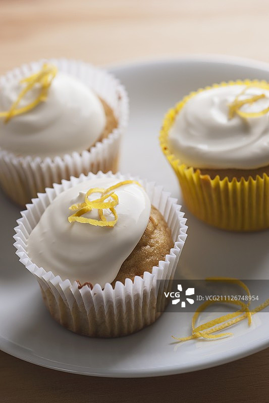三个柠檬奶油纸杯蛋糕与柠檬皮图片素材
