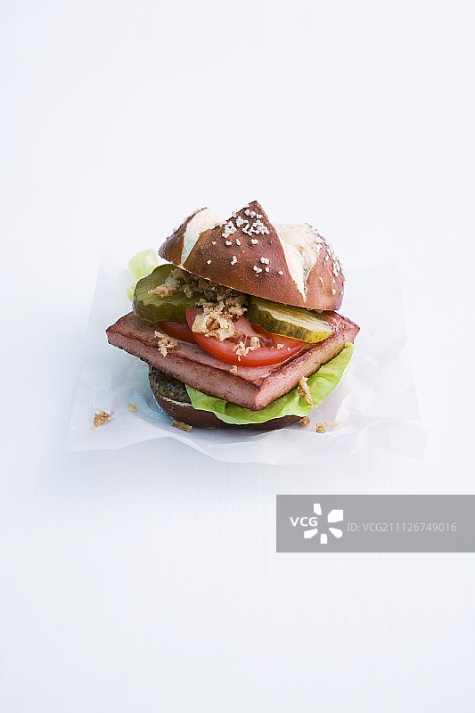 碱水面包卷配牛肉猪肉肉饼、番茄和酸黄瓜图片素材