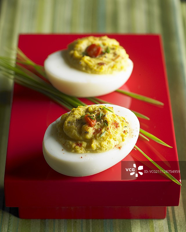 红色高脚盘上的两枚魔鬼蛋图片素材