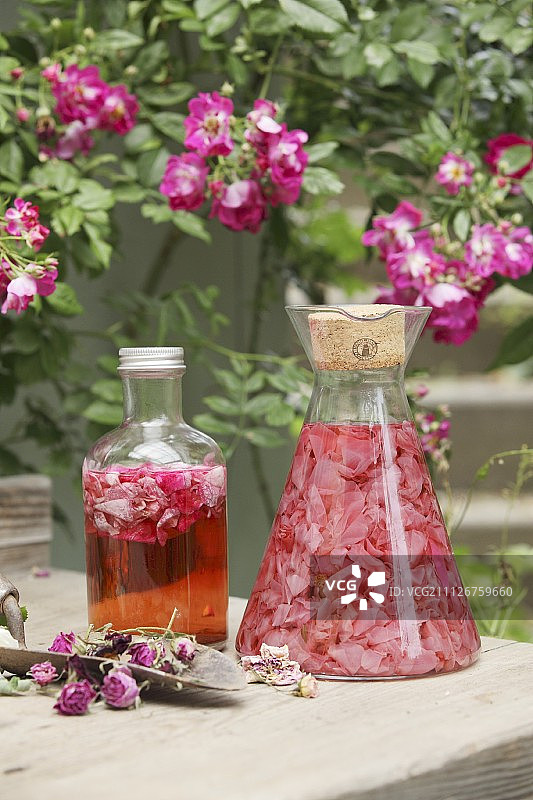 浸泡在醋中的玫瑰花瓣和一瓶玫瑰醋图片素材