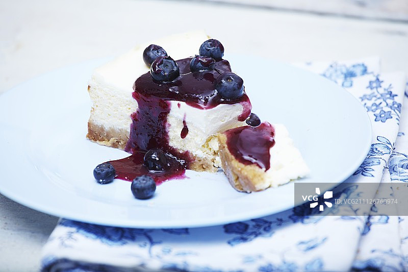 蓝莓芝士蛋糕片，白色餐盘和叉子图片素材